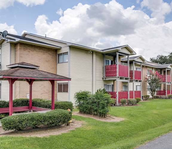 A row of apartment buildings with a red and white building in the front.