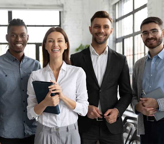 Five people are standing together in a bright room.