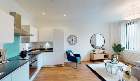a kitchen and living room with a clock on the wall at The Keel Apartments, Liverpool, L3 4GE