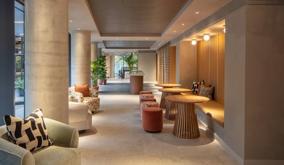 a lounge area with couches tables and chairs and large windows