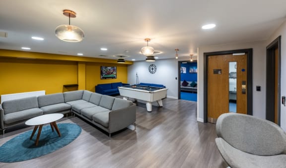 a game room with a pool table and couches