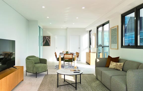 a living room with a green couch and a balcony