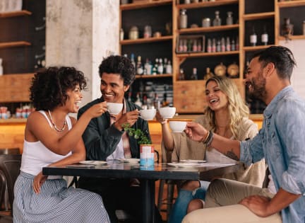 a group of people sitting at a table looking at a cell phone