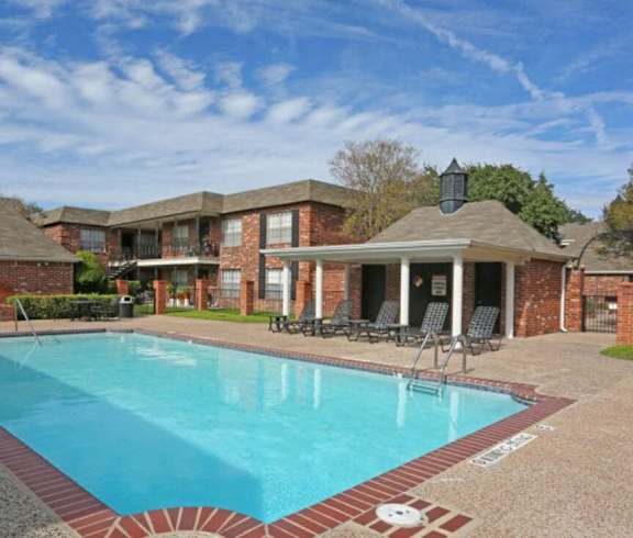 A swimming pool in a residential area with a house in the background.