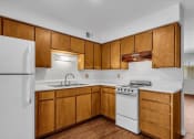 Thumbnail 1 of 9 - a kitchen with white appliances and wooden cabinets