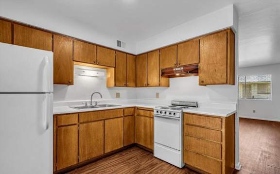 a kitchen with white appliances and wooden cabinets