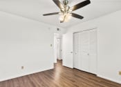 Thumbnail 8 of 9 - an empty living room with a ceiling fan and a closet