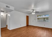 Thumbnail 6 of 9 - an empty living room with wood floors and a ceiling fan