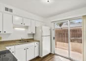 Thumbnail 4 of 9 - a kitchen with white cabinets and a sliding glass door