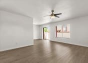 Thumbnail 4 of 11 - an empty living room with a ceiling fan and a window