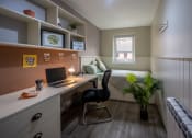 Thumbnail 2 of 8 - a small bedroom with a desk and a bed