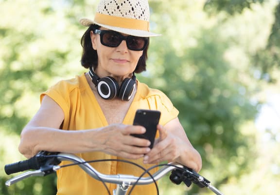 Woman looking at phone on bike Heron Pointe Apartments Miramar Florida