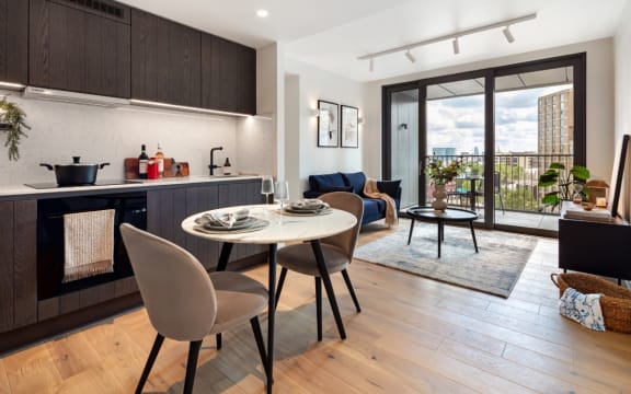 an open concept living room and kitchen with a large glass door leading to a balcony