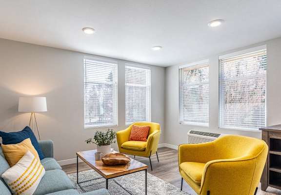 a living room with yellow chairs and a couch