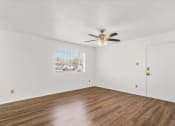 Thumbnail 5 of 9 - an empty living room with white walls and a ceiling fan