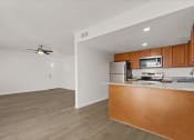 Thumbnail 3 of 11 - an empty living room with a kitchen and a counter top