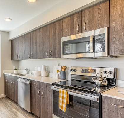 134th street lofts kitchen with wooden cabinets. stainless steel  stove, microwave and dishwasher