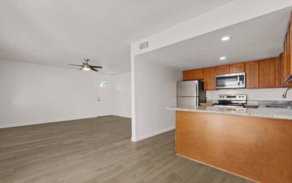 an empty living room with a kitchen and a counter top