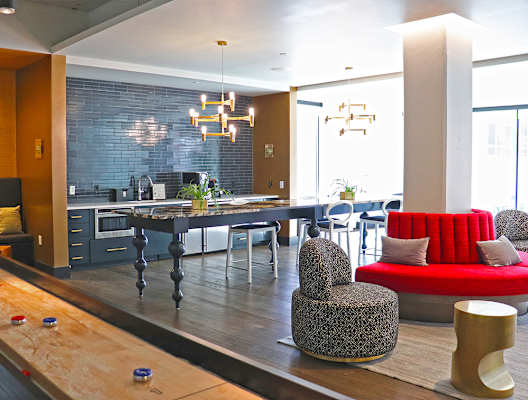 A modern dining area with a long table and chairs. at The Elle on Lockwood Apartments, Webster Groves, MO, 63119