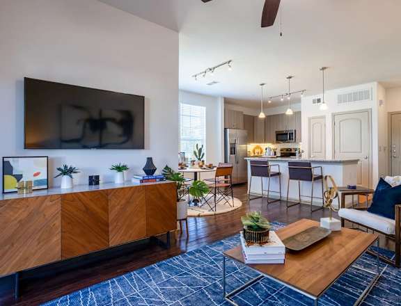 A modern living room with a wooden cabinet and a blue rug on the floor.