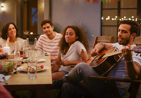 Lifestyle photo of friends playing the guitar and having fun at The Edge at Town Center Apartments, Jacksonville