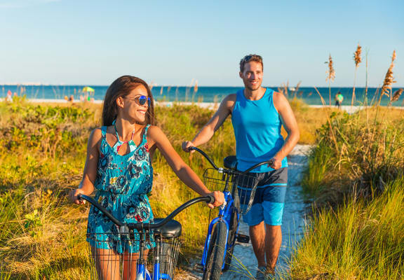 Lifestyle photo of couple on bikes at the beach