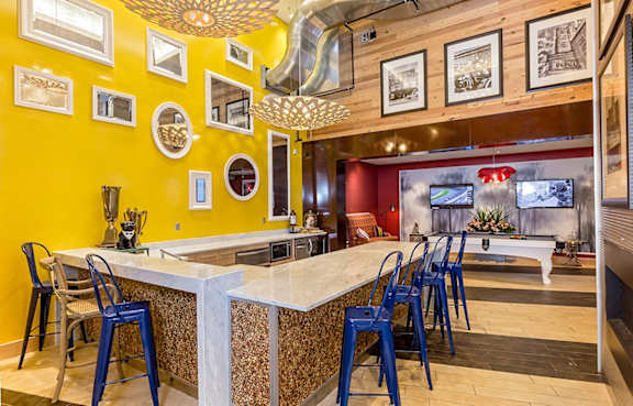 a bar with blue chairs at a restaurant with a pool table