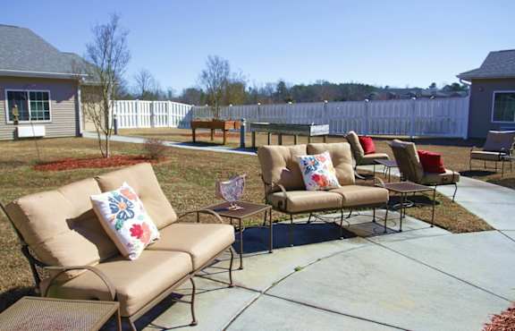 A patio with a couch and chairs.