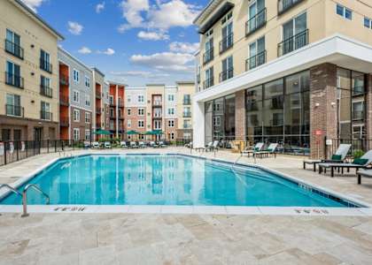 A large swimming pool in front of apartment buildings.