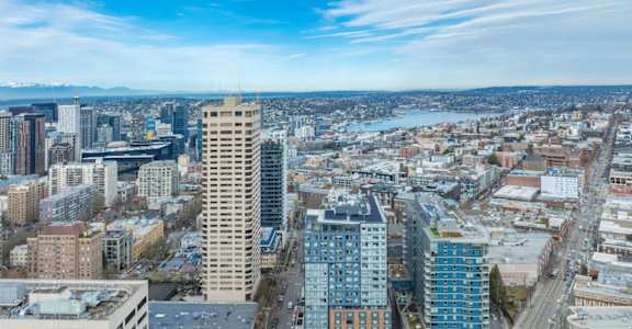 A cityscape with a mix of modern and older buildings under a clear sky.