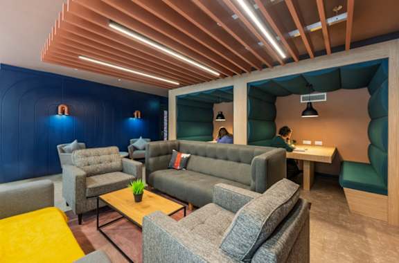A modern lounge area with grey and yellow accent chairs.