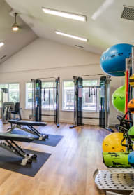 a gym with cardio equipment and weights on a wooden floor