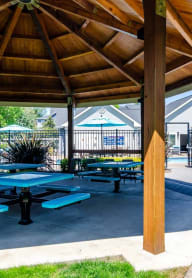a large pavilion with picnic tables and a grill