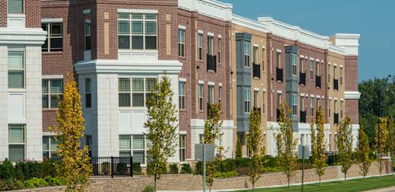 a row of apartment buildings with trees in front of them  at The Grandstone, Mason, 45040