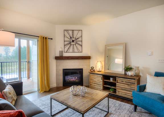 a living room with a fireplace and a sliding glass door to a balcony