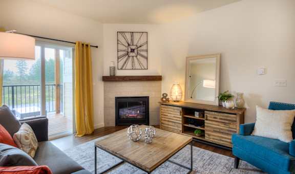 a living room with a fireplace and a sliding glass door to a balcony