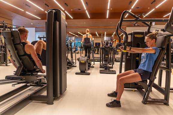 A gym with people working out on machines.