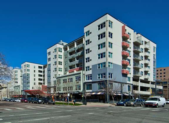 A large white building with a red awning sits in front of a parking lot.