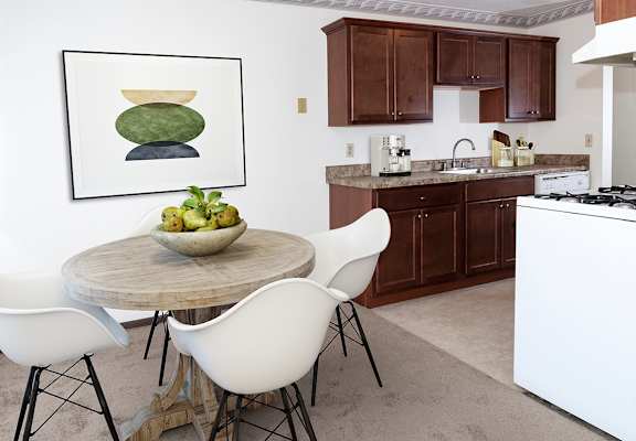 a kitchen and dining area with a table and chairs and a painting on the wall