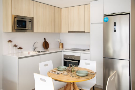 a kitchen with a table and chairs and a refrigerator