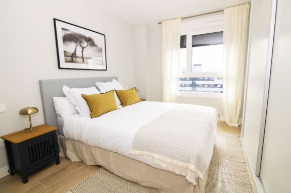 a bedroom with a large white bed and a window