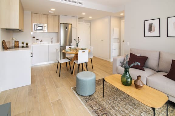 a living room with a couch and a table and a kitchen