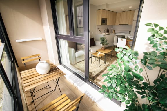a small balcony with a table and chairs and a kitchen