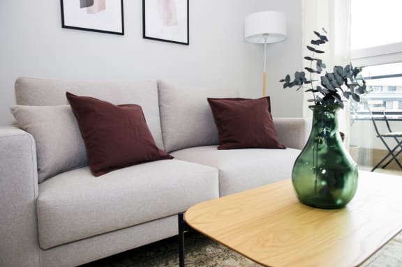a living room with a couch and a table with a vase of flowers