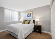 Thumbnail 3 of 3 - A bedroom with a large bed and a painting on the wall.