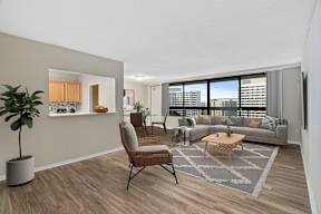 a living room with a large window and a view of the kitchen