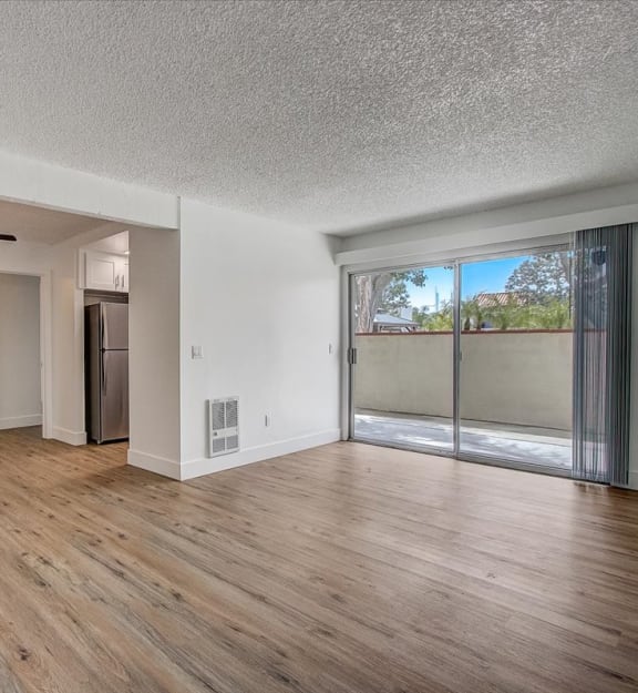 an empty living room with a sliding glass door