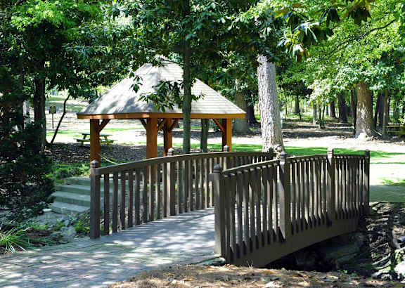 a bridge and a gazebo in a park