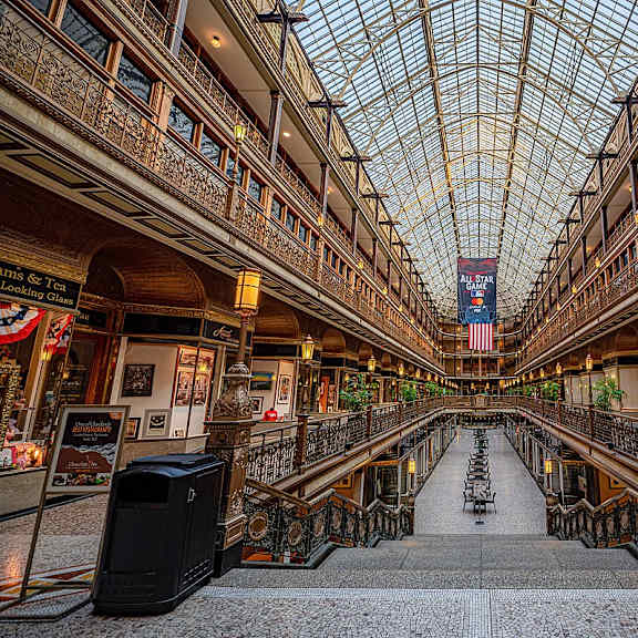 A large atrium with a glass ceiling and a staircase in the middle.