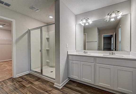 a bathroom with a large mirror and a walk in shower